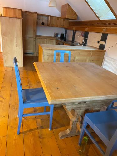 cocina con mesa de madera y sillas azules en Apartment Lindbichler, en Bad Hofgastein