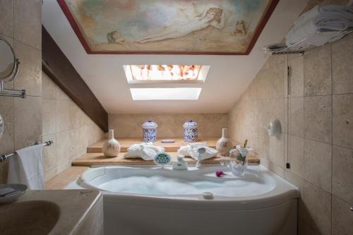 a bathroom with a sink and a bath tub at UNICA Assisi agri-charming house in Assisi