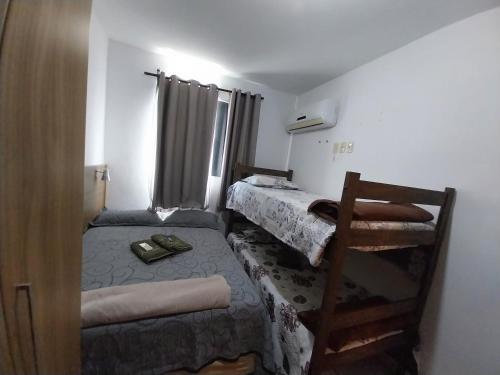 um pequeno quarto com duas camas e uma escada em Apto Richard Shopping em Campos dos Goytacazes