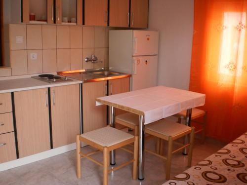 a kitchen with a table and two chairs and a table at Apartments Odzic in Tivat