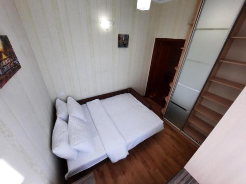 um pequeno quarto com uma cama branca e um espelho em Двокімнатна квартира в центрі біля готелю Палаццо Мережа Alex Apartments Безконтакнте заселення 24-7 em Poltava