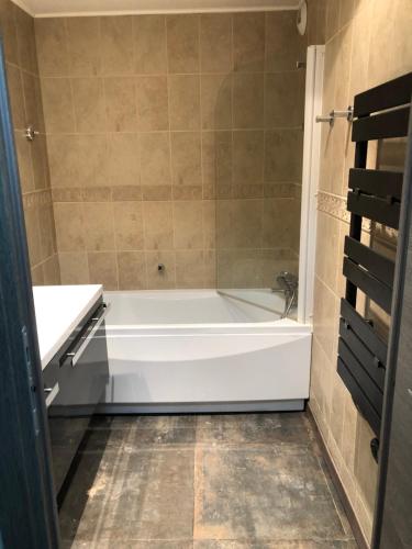 een badkamer met een wit bad en een wastafel bij Les Terrasses d Isola 2 pièces 4 personnes in Isola 2000