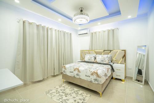 a bedroom with a bed and a blue ceiling at Chuchi Place in Santiago de los Caballeros