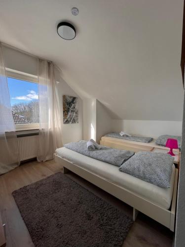 1 dormitorio con 2 camas y ventana en Hotel Breuer, en Hamm