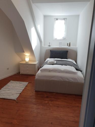 ein weißes Schlafzimmer mit einem Bett und einem Fenster in der Unterkunft Nilos Apartment in Diez