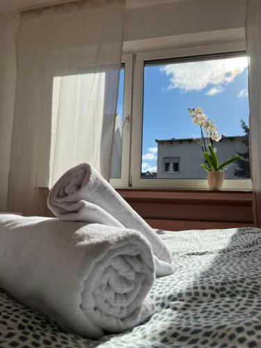 a bed with a towel on it with a window at Hotel Breuer in Hamm