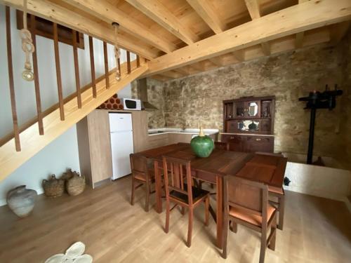 a dining room with a wooden table and a staircase at Casinha da Avó Rosário in Juncal