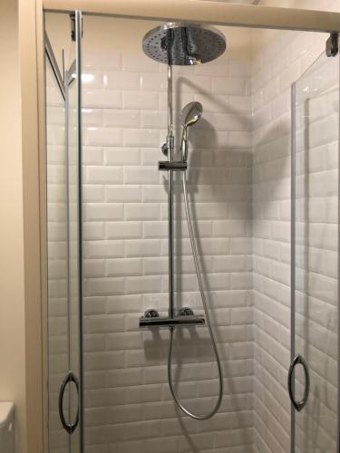 een douche met een douchekop in de badkamer bij Hôtel de la Glane in Oradour-sur-Glane