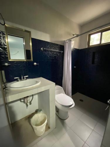 a bathroom with a sink and a toilet and a mirror at Hotel El Rincon de Don Juan in Tecolutla