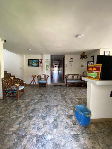 a living room with chairs and a table and a television at Hotel El Rincon de Don Juan in Tecolutla