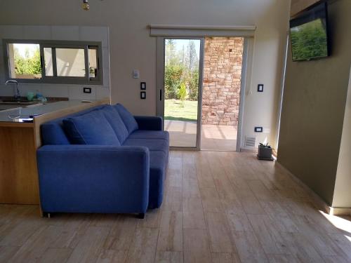 a living room with a blue couch and a kitchen at De Alma Tinta - Petit Chalet in San Rafael