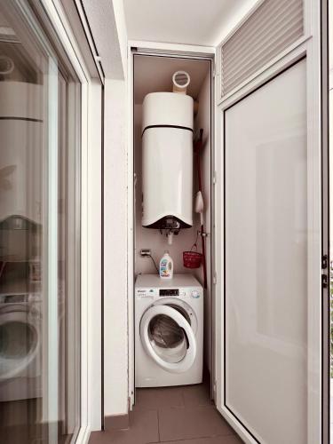 a small laundry room with a washer and dryer at Dimora Punta Azzurra- Enjoy Apulia in Polignano a Mare