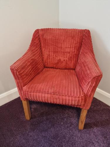 a red chair sitting in the corner of a room at Home Inn in Athlone