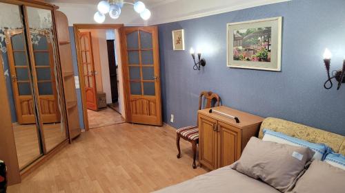 - un salon avec un lit et un mur bleu dans l'établissement Апартаменти на Проспекті., à Khmelnytsky