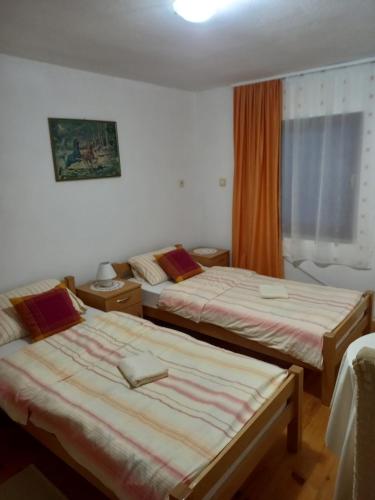 um quarto de hotel com duas camas e uma janela em Sobe Dujakovic 
