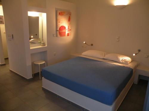 a small bedroom with a bed and a mirror at Zathea Apartments in Agia Pelagia Kythira