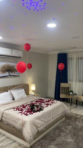 a bedroom with red balloons on top of a bed at لورينا شالية in Al Hofuf