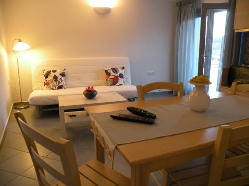 a living room with a dining table and a bed at Zathea Apartments in Agia Pelagia Kythira