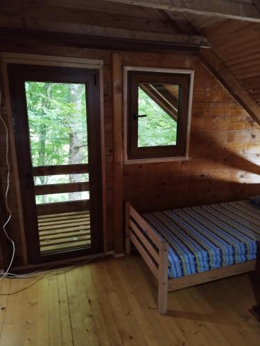 um quarto com duas janelas num chalé de madeira em Kuca u sumi em Bijelo Polje