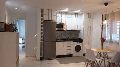 a kitchen with a refrigerator and a table with chairs at Casa Palacio Arcos del Carmen in Jerez de la Frontera
