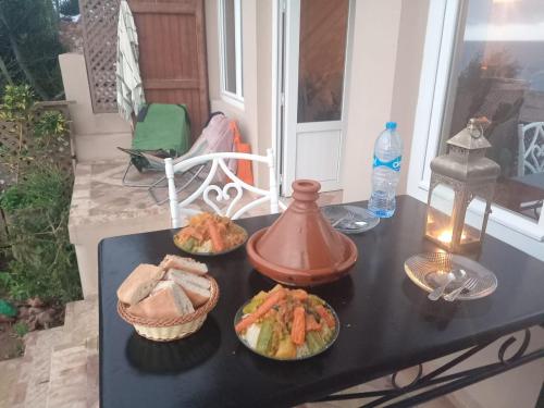 a table with three plates of food on it at Dar diafa samira in Mirleft