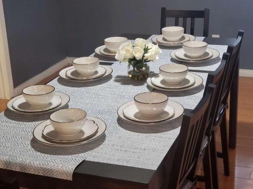 a table with plates and cups and a vase of flowers at Sun Angel House #2 Pahrump in Pahrump