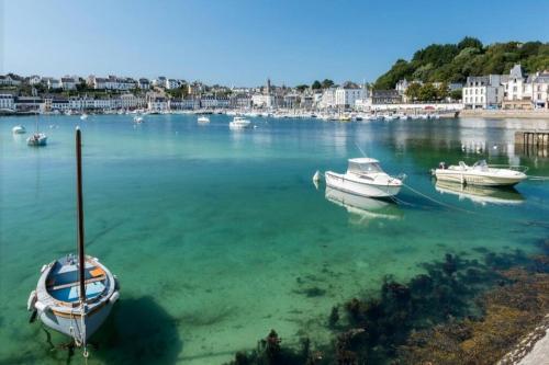 Trois bateaux sont amarrés dans l'eau d'un port dans l'établissement studio entier 2 personnes centre ville, à Audierne