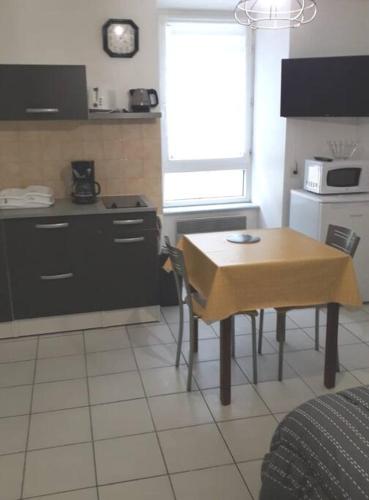 une cuisine avec une table et une petite cuisine avec une cuisinière dans l'établissement studio entier 2 personnes centre ville, à Audierne
