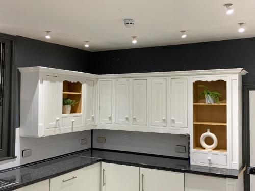 a white kitchen with black walls and white cabinets at Gorgeous Central Hastings Old Town in Hastings