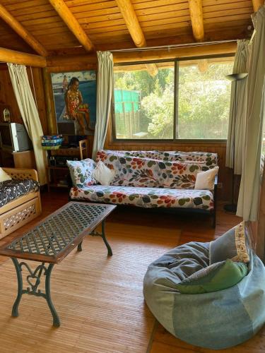 a living room with a couch and a table at Maravillosa cabaña en orilla de Lago Vichuquén in El Rodeo