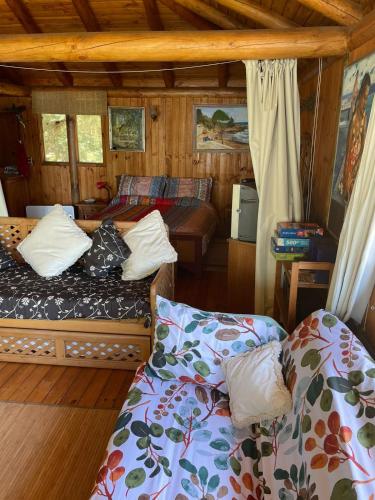 a bedroom with two beds in a wooden cabin at Maravillosa cabaña en orilla de Lago Vichuquén in El Rodeo