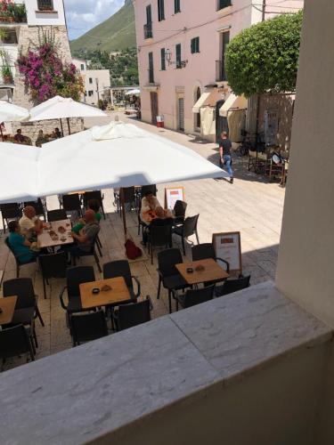 a group of people sitting at tables under an umbrella at Casa Cardi in Sperlonga