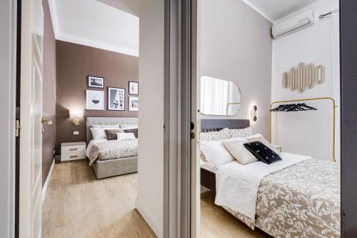 1 dormitorio con 2 camas y espejo en BDC - The Choice, your 2-Bdr apt in Vatican district, en Roma