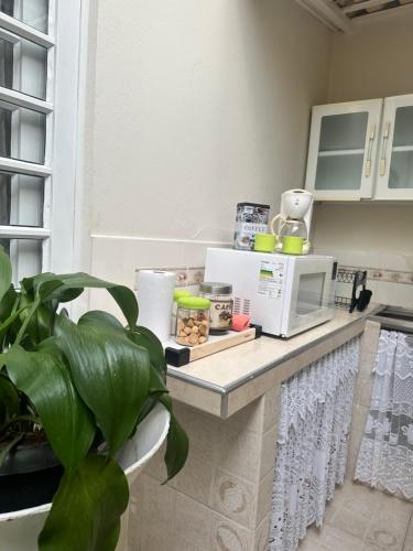 a kitchen with a counter with a microwave on it at Deck Hospedaria in Cunha