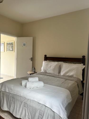 a bedroom with a large bed with two towels on it at Deck Hospedaria in Cunha