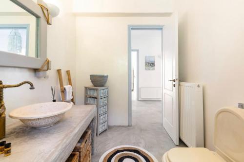 a bathroom with a counter with a sink and a toilet at Petra House Kea 12776742 in Koundouros