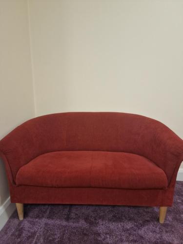 a red couch sitting in a room at Home Inn in Athlone