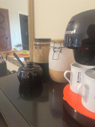 a counter with cups and a coffee maker on it at Deck Hospedaria in Cunha