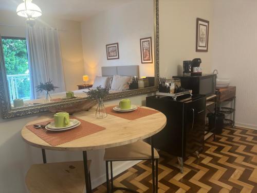 a living room with a table and a mirror at Deck Hospedaria in Cunha