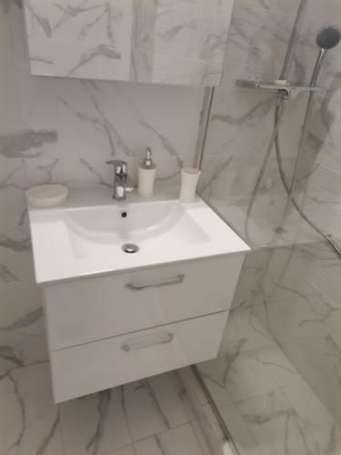 a bathroom with a white sink and a mirror at S & K Apartment free indoor parking in Athens