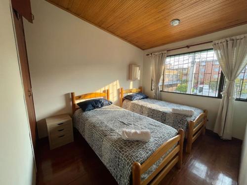 a bedroom with two beds and a window at Casa Linda in Bogotá