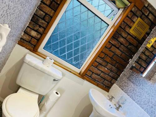 un piccolo bagno con servizi igienici e finestra di Treetops - Sleeps 8 entire house private parking close to town centre and stadium a Wigan