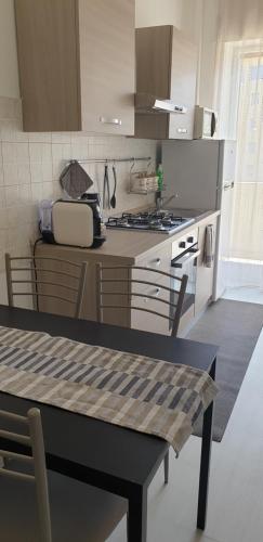 una cucina con tavolo e piano cottura forno superiore di AMAVERONA APARTMENT a Verona
