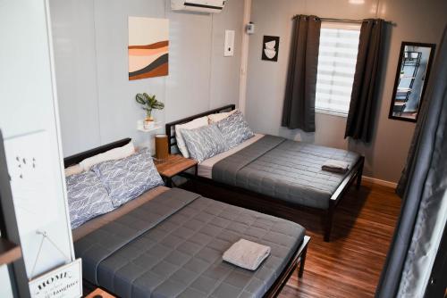 a living room with two beds and a couch at Olive Hostel Roxas City in Roxas City