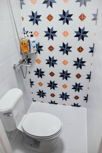 a bathroom with a toilet and a wall covered in stars at Olive Hostel Roxas City in Roxas City