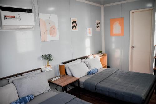 a bedroom with a bed and a table and a bed sidx sidx sidx at Olive Hostel Roxas City in Roxas City