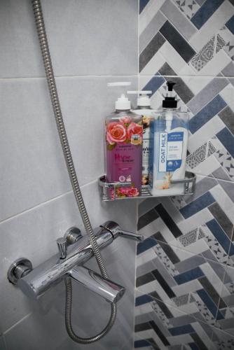a bathroom with a shelf with toiletries on it at Olive Hostel Roxas City in Roxas City