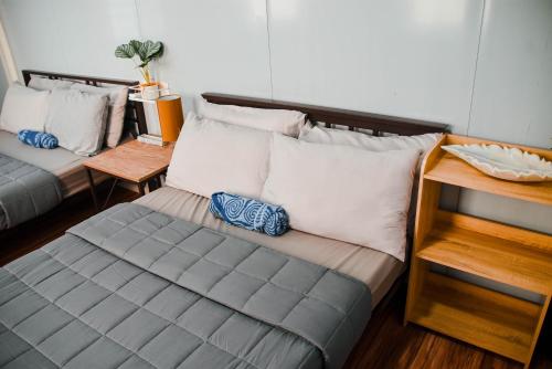 a bedroom with two beds with pillows at Olive Hostel Roxas City in Roxas City