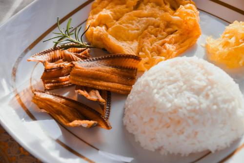 a plate of food with rice and meat on it at Olive Hostel Roxas City in Roxas City