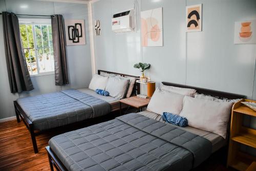 a living room with two beds and a couch at Olive Hostel Roxas City in Roxas City
